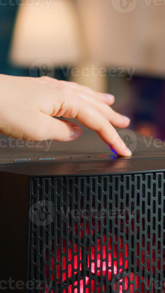 Professional esports gamer operating pc system, pressing on start button of computer unit. Woman preparing for gaming tournament, cyber performing in stylish room playing online shooter game photo