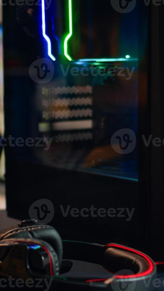 Powerful gaming unit with colorful RGB lights prepared for gaming tournament in living room at night. Cyber performing in stylish room playing online shooter game. photo