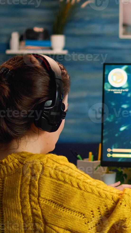 Esport of pro gamer wearing headset playing game with new graphics during championship sitting at home. Virtual shooter game in cyberspace, esports player performing on pc gaming tournament photo