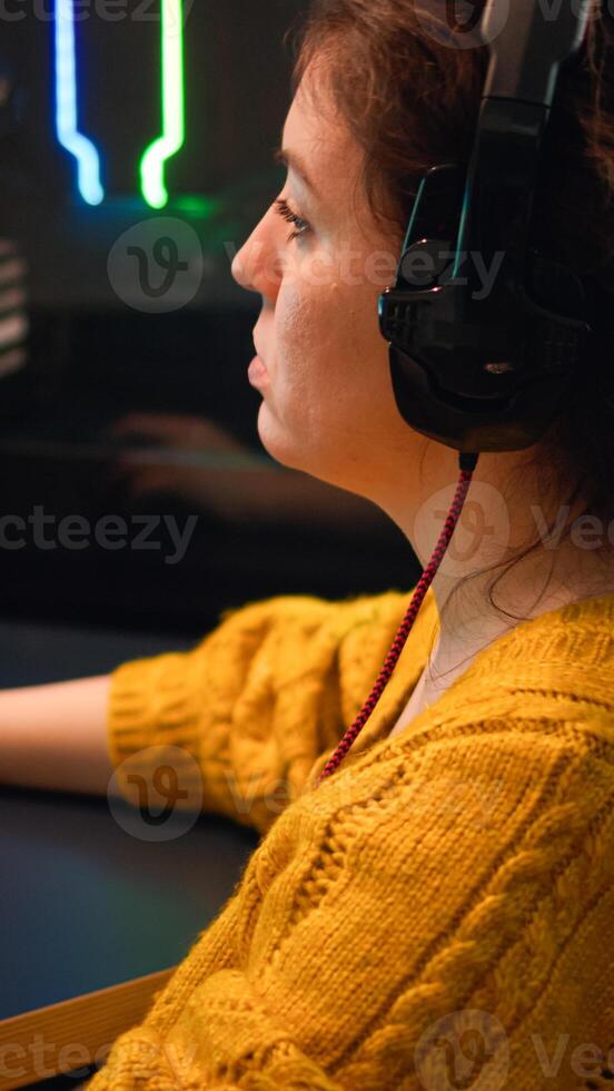 Pro gamer talking with teammates through headphones playing shooter game having championaship. Virtual shooter game in cyberspace, esports player performing on pc gaming tournament photo