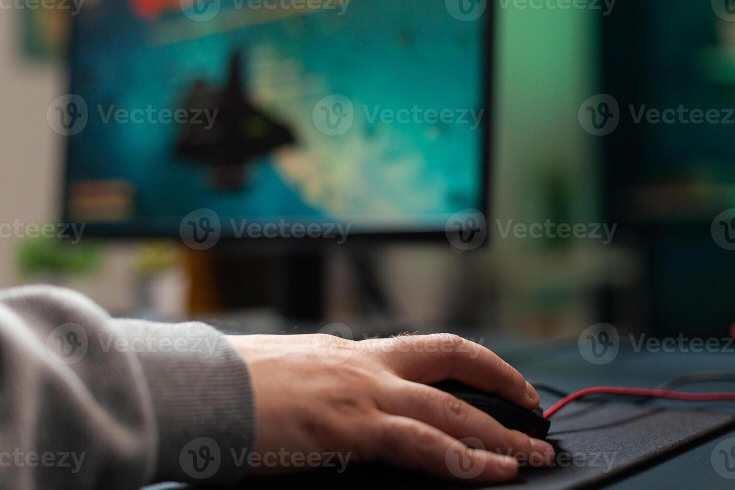 Close up of player holding mouse with mousepad on desk to play games. Man using gaming equipment on computer, playing online game. Hand of player on gadget having fun with games photo