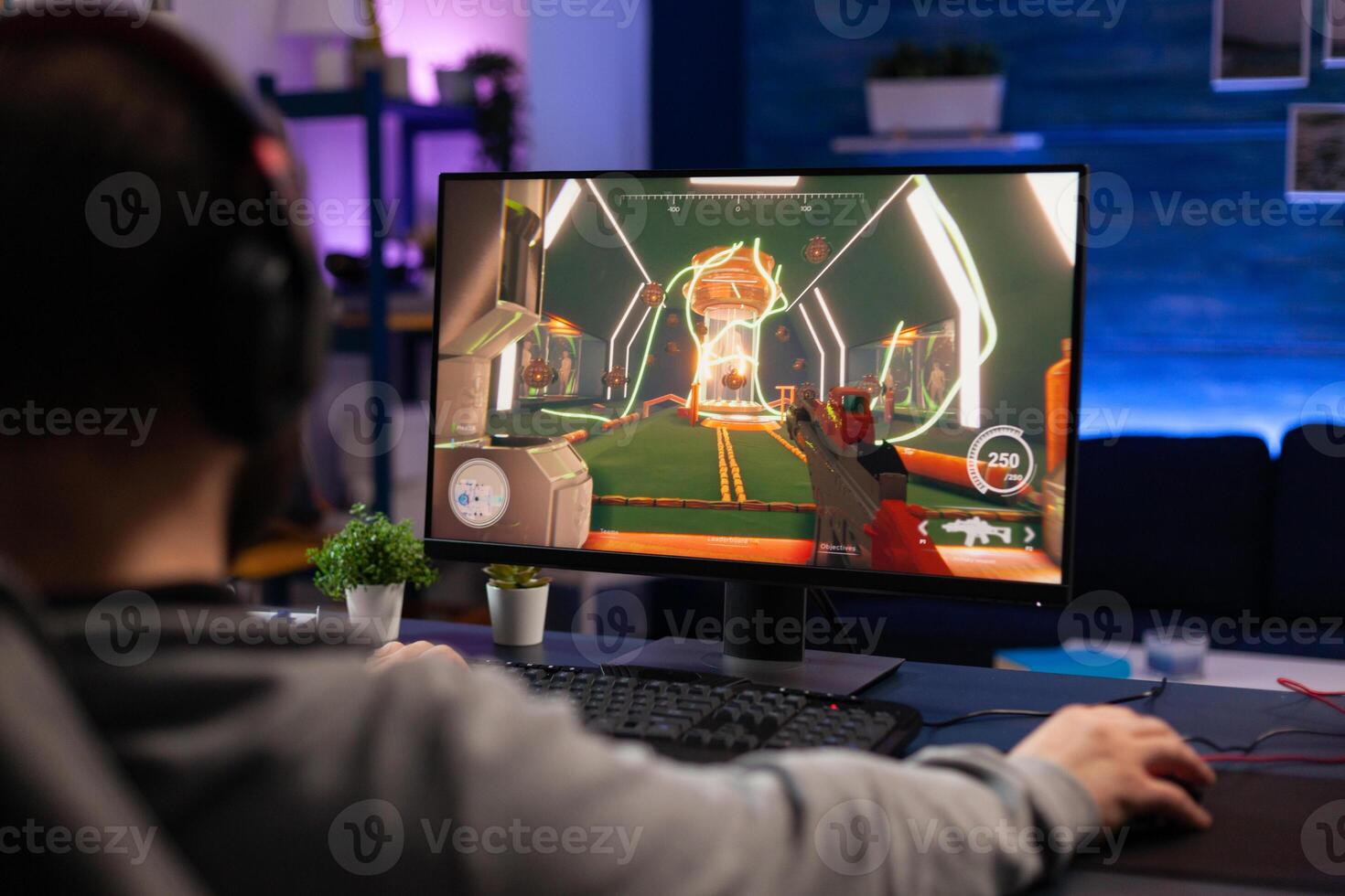 Man playing games on computer with mousepad and headphones. Gamer using mouse and headset to play online games on monitor. Player having fun with gaming equipment and electronic game photo