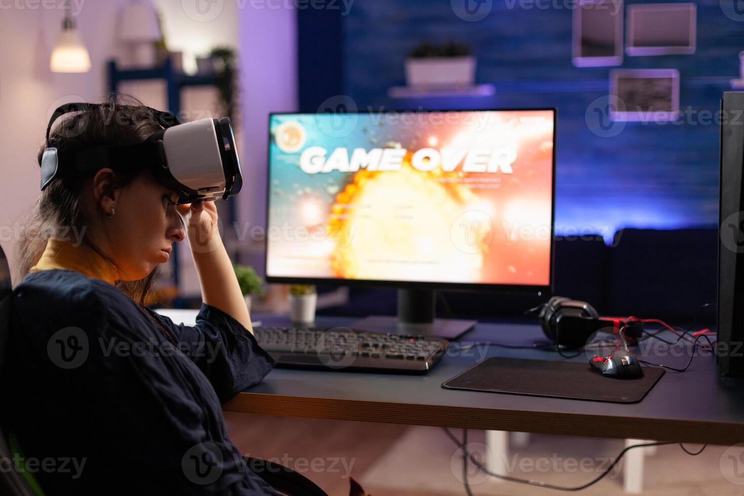 Gamer using vr goggles to play games and losing on computer. Person playing online game with controller on monitor and virtual reality glasses. Adult with gaming equipment. photo