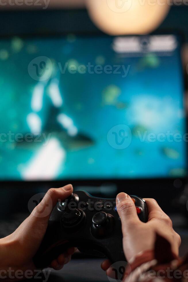 Close up of woman holding joystick and playing games on computer. Gamer using controller to play online digital games in front of monitor. Person with modern gaming equipment photo