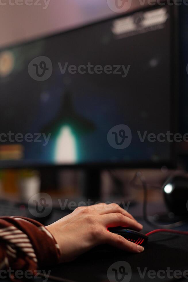 Close up of hands using mouse to play games on computer. Gamer playing digital game with mouse and pad in front of monitor to have fun. Player using online gaming equipment photo