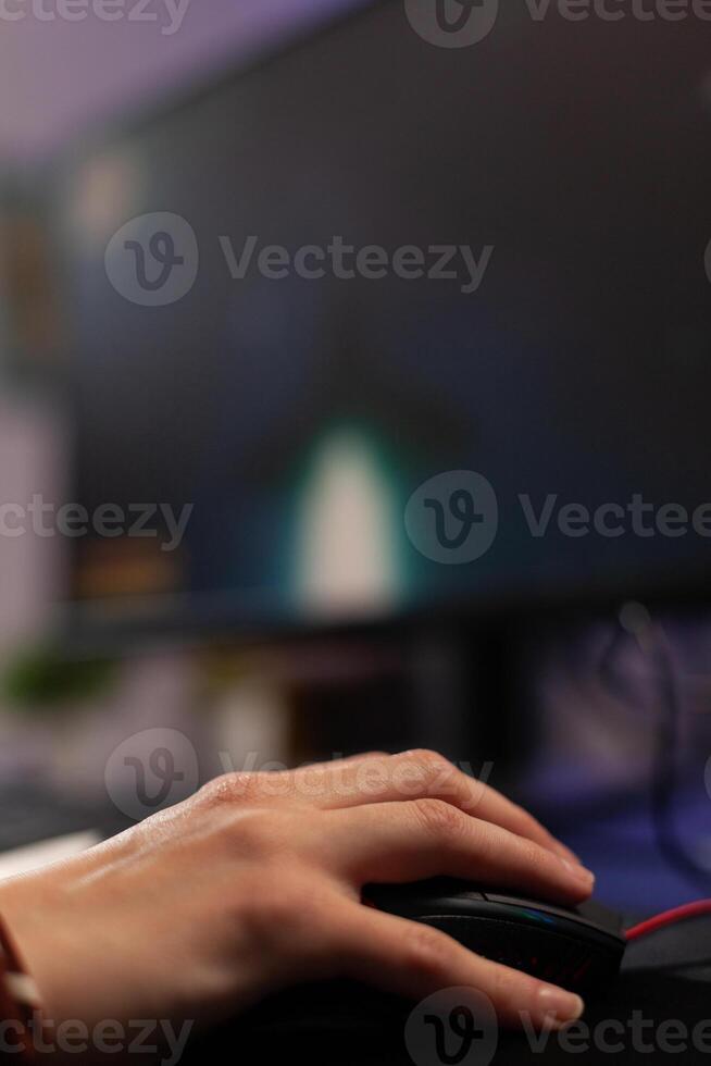 Close up of woman using mousepad to play games on computer. Gamer playing digital game with mouse and pad in front of monitor to have fun. Player using online gaming equipment photo