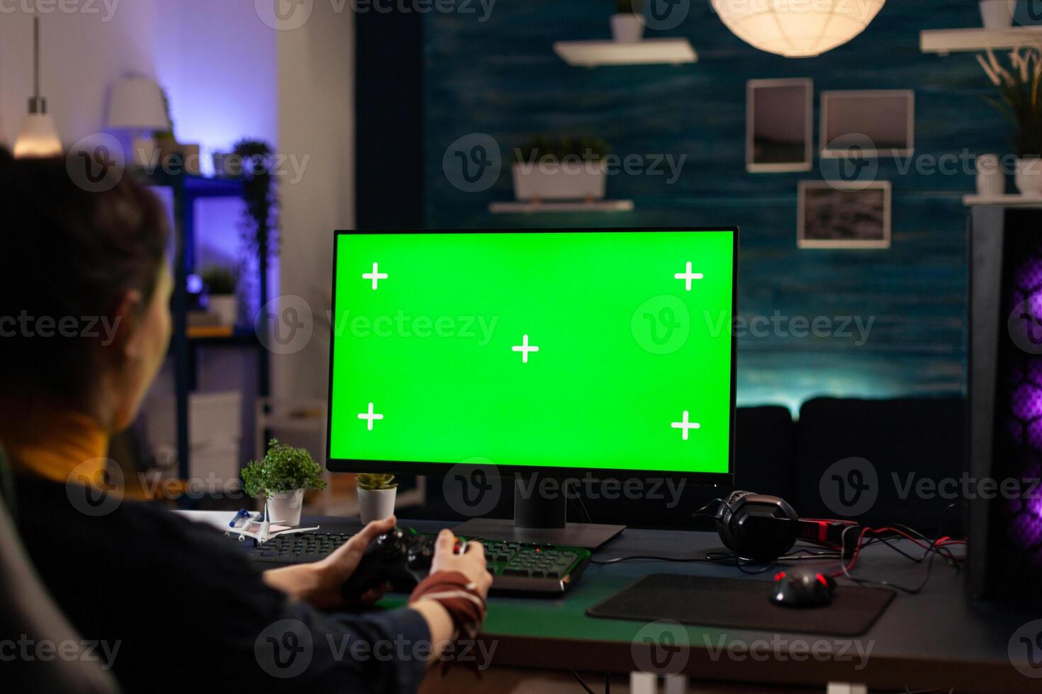 Player using horizontal green screen on computer, playing games with controller. Woman looking at chroma key with isolated background and mockup template on monitor display. photo