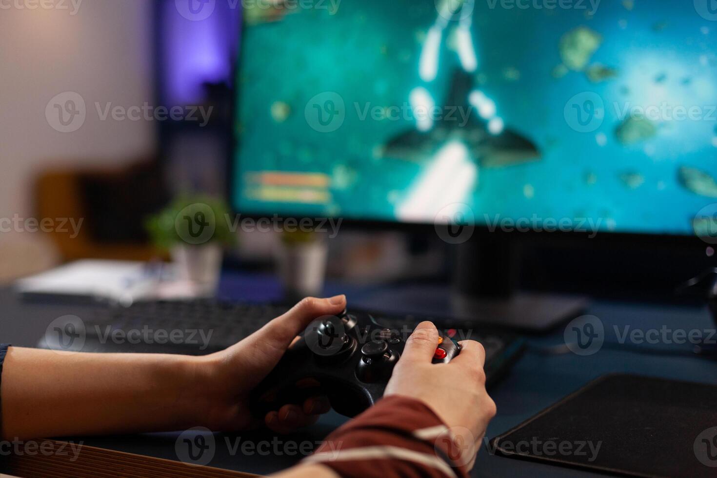 Close up of person using joystick to play games on monitor. Woman holding controller and playing digital games on computer. Person with gaming equipment to play online game. photo