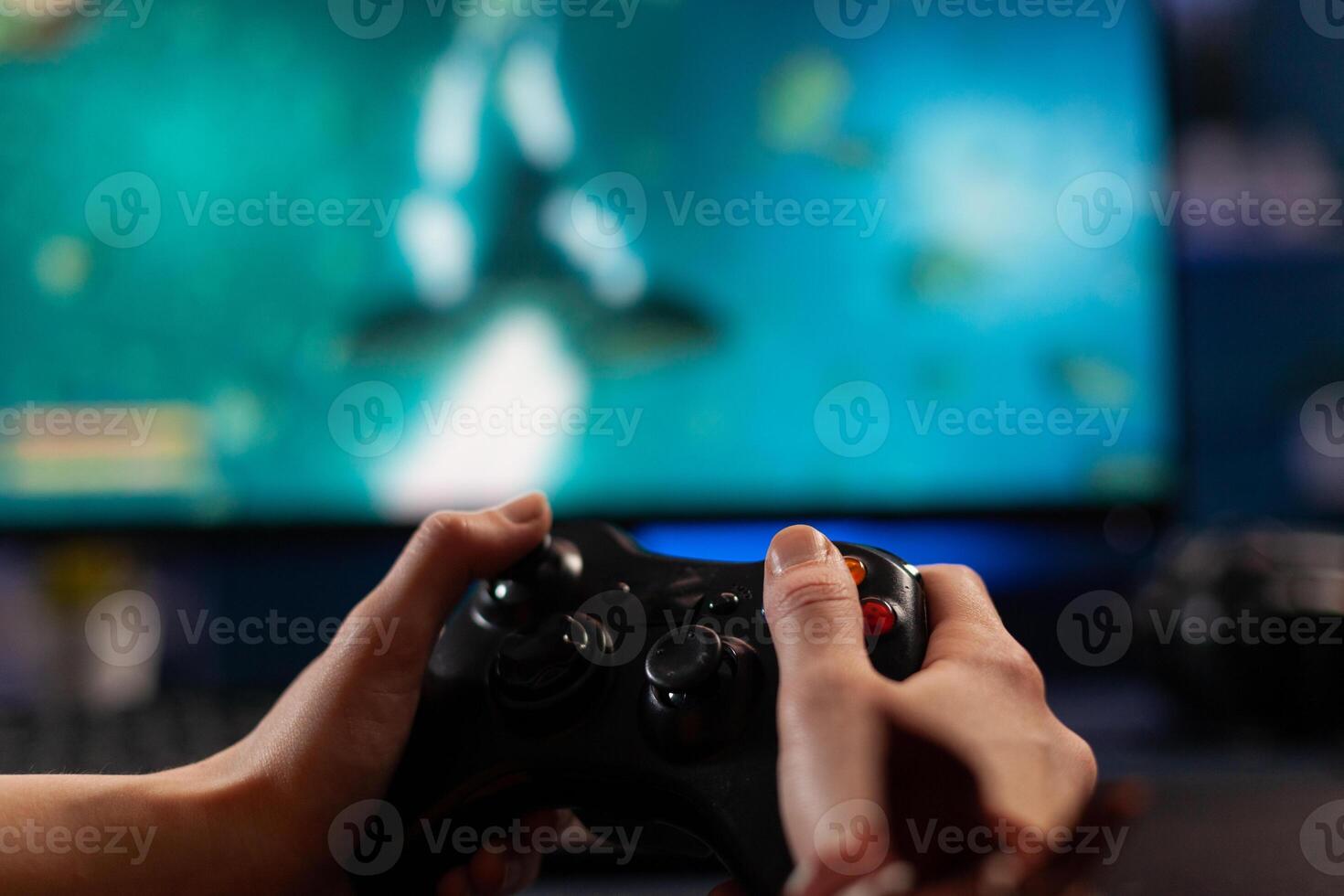 Close up of gamer holding controller and playing games on computer. Woman using joystick to play online digital games in front of monitor. Person with modern gaming equipment photo