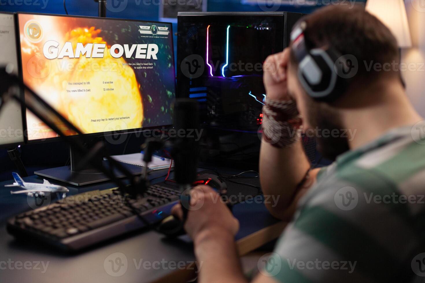 Adult playing games on live stream with chat and losing. Man using headphones and microphone to broadcast gameplay, streaming lost game on computer. Gamer live streaming online. photo