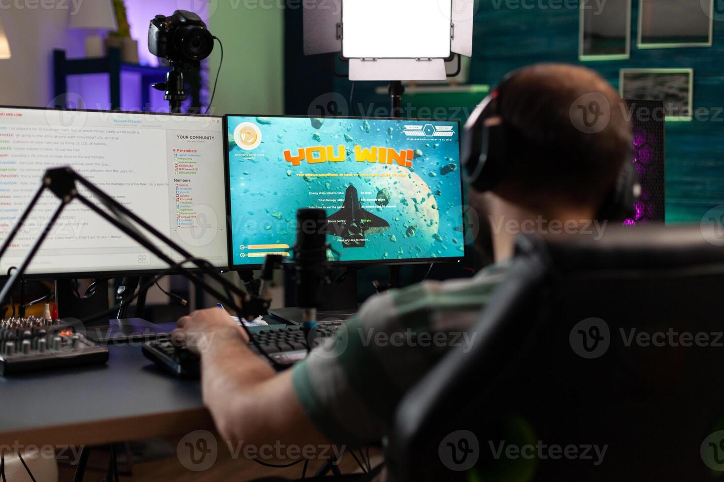 Player winning gameplay with live chat on stream. Man streaming and playing games, celebrating win on computer. Gamer using microphone and headset while he is live streaming. photo