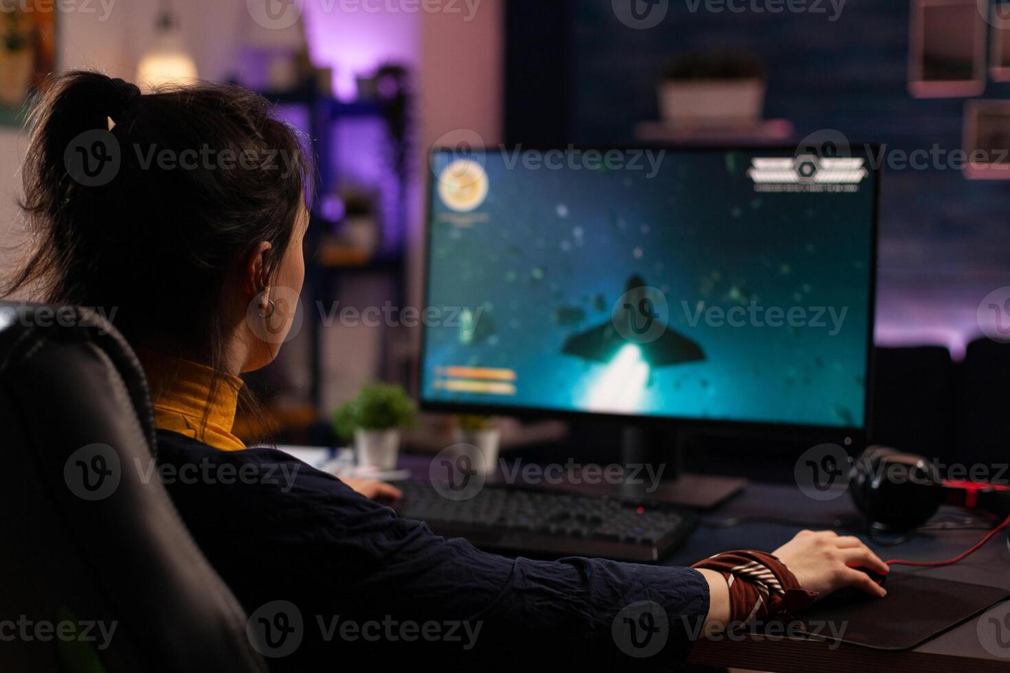 Adult using keyboard and mousepad to play games on computer. Gamer playing online game in front of monitor with control console and mouse on desk. Modern player with gaming equipment photo