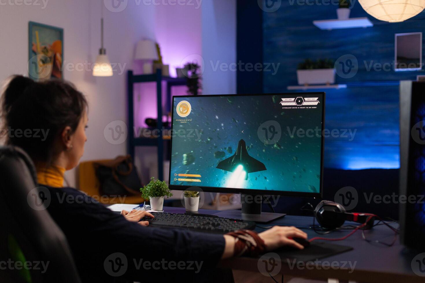 Person using keyboard and mouse to play games on computer. Gamer playing online game in front of monitor with control console and mousepad on desk. Modern player with gaming equipment photo