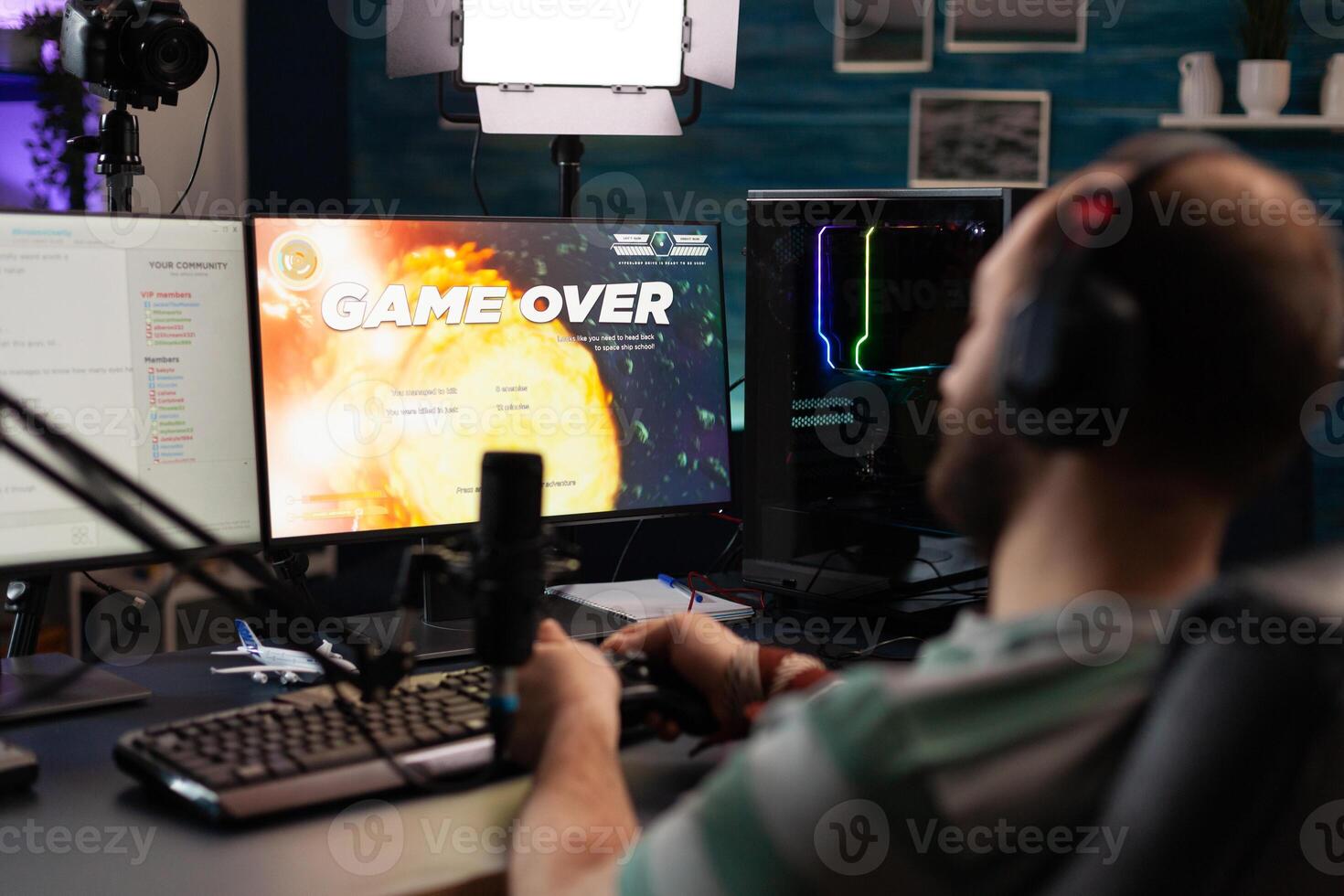 Man streaming games with microphone and losing on computer. Gamer looking at monitors with live stream chat and online game, playing and broadcasting gameplay with headphones. photo