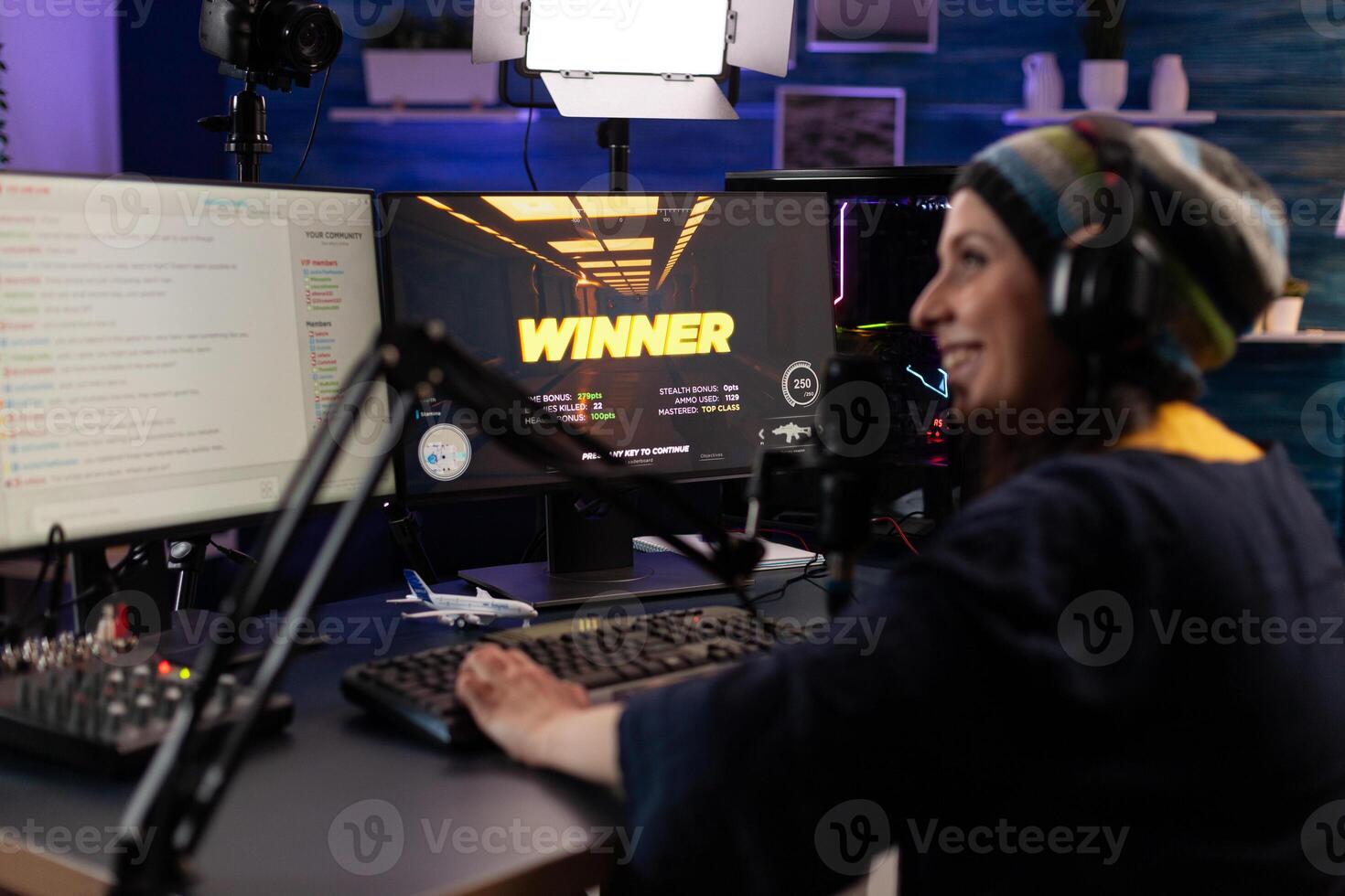 Player winning games on live stream with chat. Woman streaming gameplay online on computer with hmicrophone and headphones. Person broadcasting while she plays game. photo