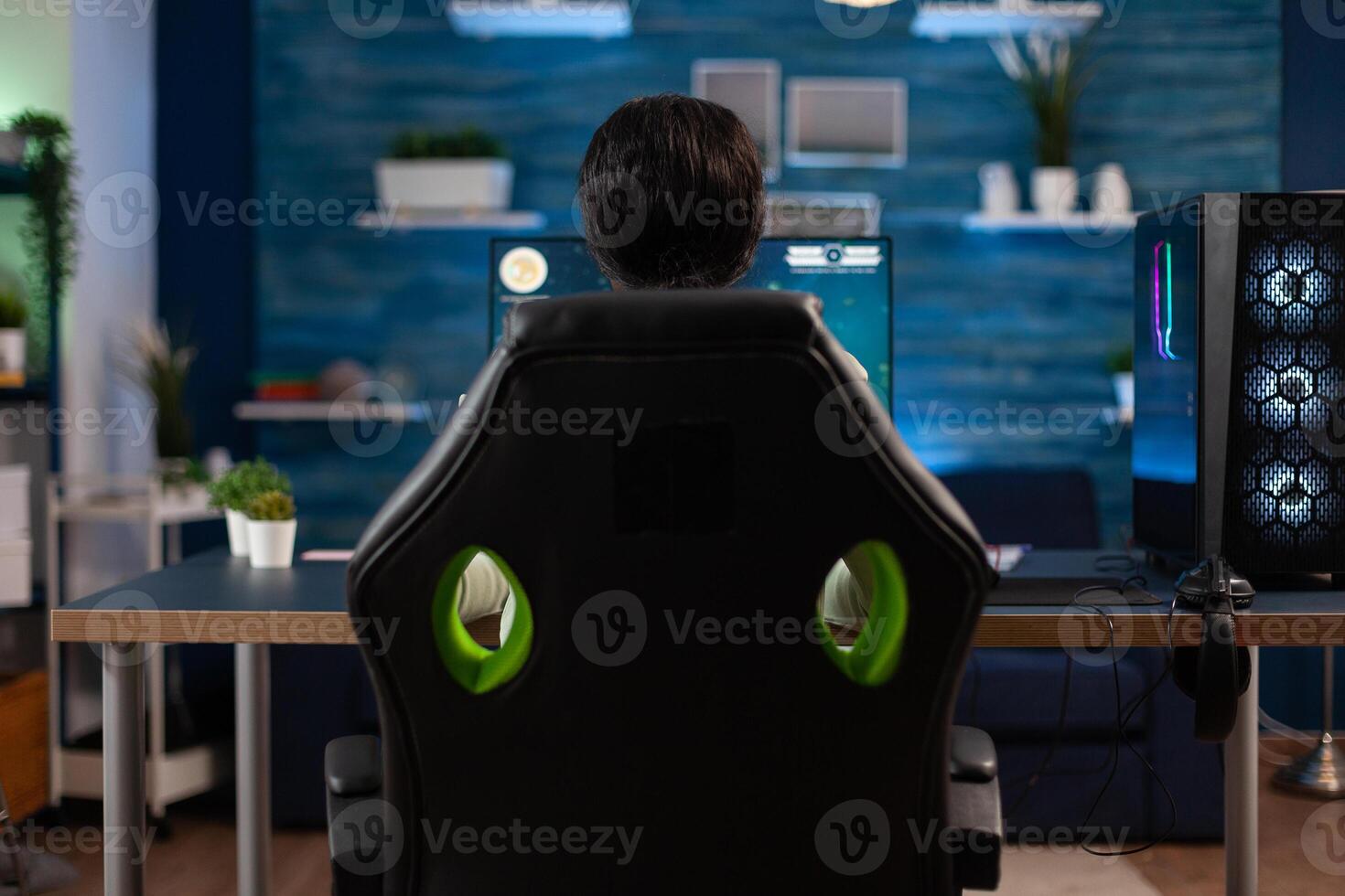 Concentrated gamer playing space shooter games during online competition using gaming joystick in streaming home studio. Streamer woman using professional RGB computer equipment. Cyber space photo