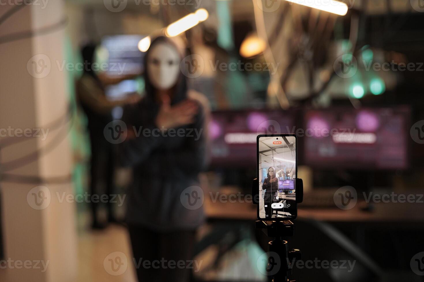 Hacking thief filming live ransomware late at night, threatening to expose important information after breaking encryption. Spy with anonymous mask hacking database system with trojan virus. photo