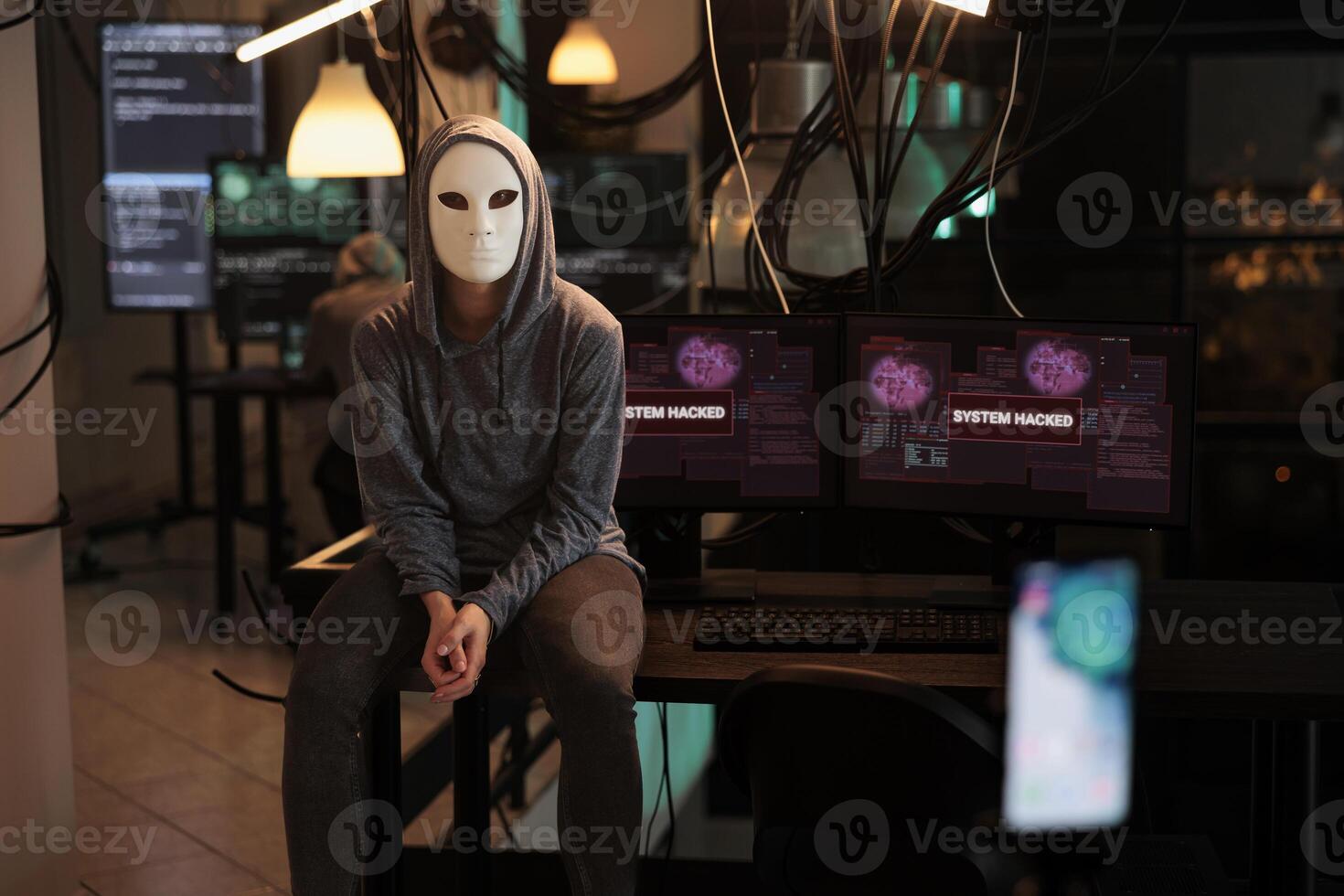 Anonymous hacker recording ransomware , hacking computer system and breaking into online server. attacking database. Woman thief stealing information, planting virus on software. photo