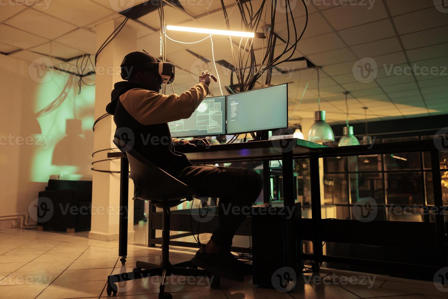 Online criminal using multi monitors and vr glasses to crack encryption and steal passwords. Man trying to hack computer network and system, working with virtual reality headset. photo