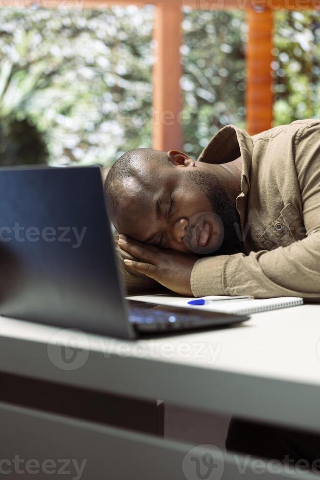 Administrator financial advisor falling asleep while he works from home, dealing with burnout and stress from online business operations. Entrepreneur takes a nap feeling exhausted. photo