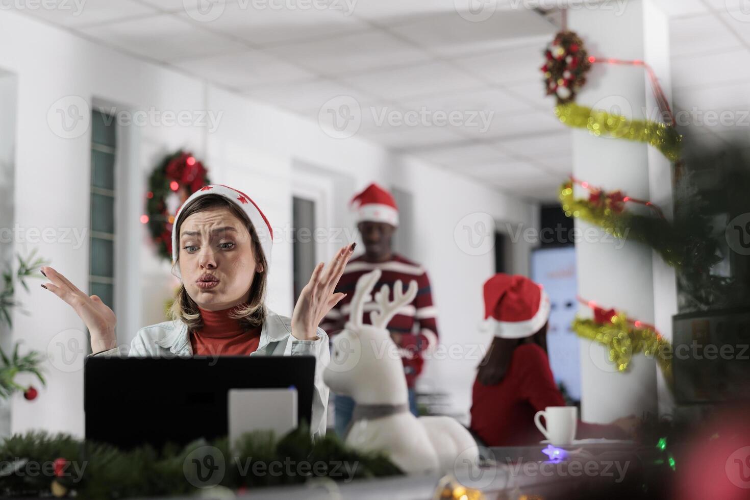 Office worker stressed by difficult paperwork with deadline approaching soon during Christmas holiday season. Exhausted employee overworked by stressful project in festive ornate workplace photo
