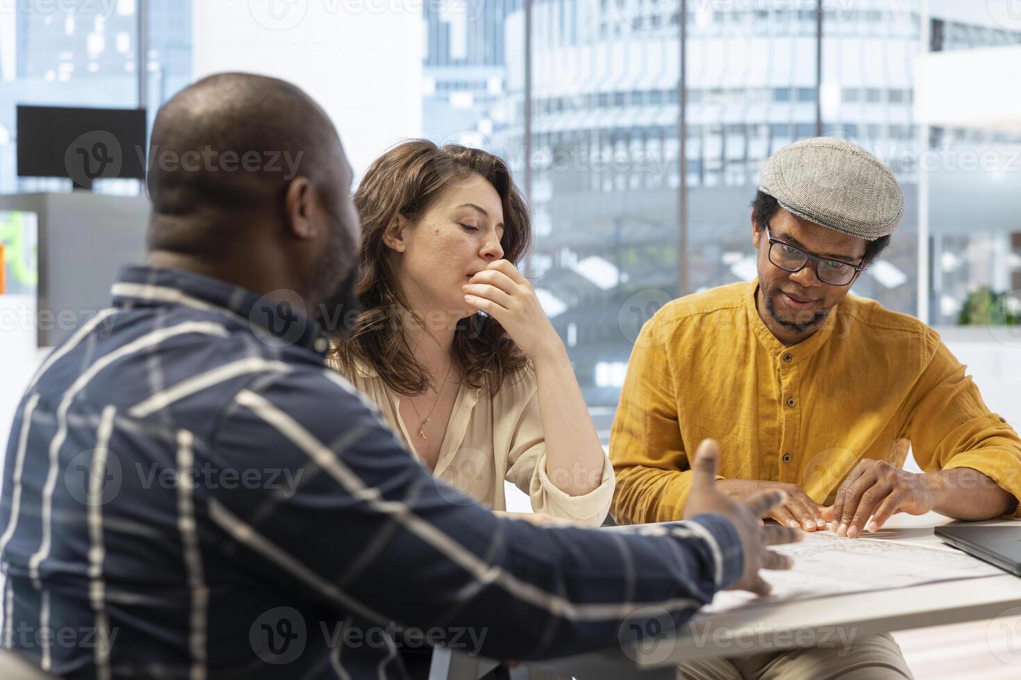 Client and realtor studying architectural plans for the property layout, evaluating investment opportunity at the end of an office tour. Studying blueprints during a meeting with salesman. photo