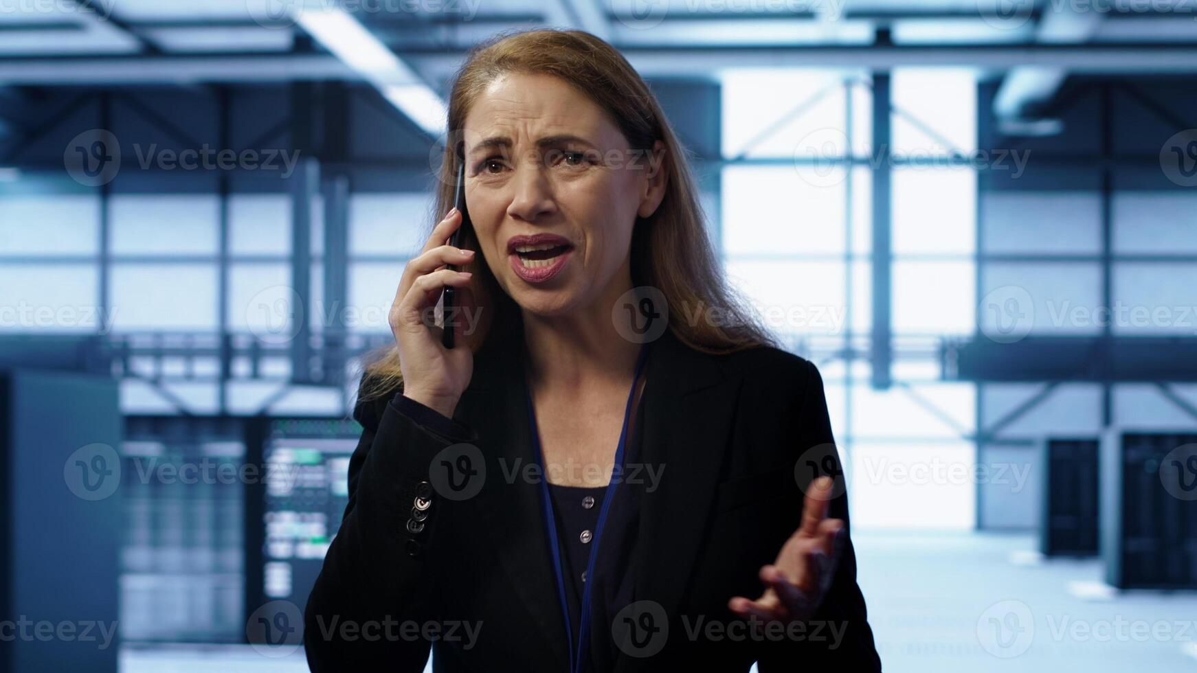 Technician in data center talking in phone call, doing yearly inspection. On field system administrator talking with manager in server hub during telephone call, monitoring servers, camera A photo