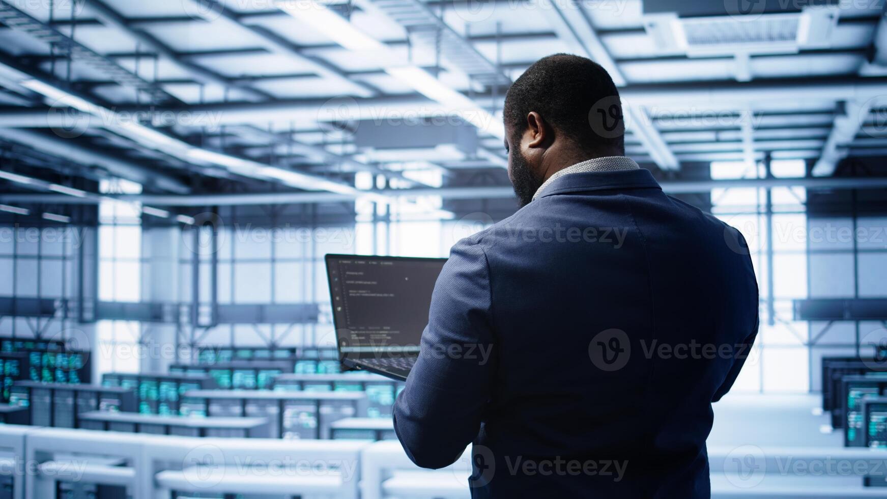 African american admin in data center running error checking utilities on tablet to fix hardware bugs. IT expert in server hub workspace looking for issues affecting mainframes performance, camera B photo