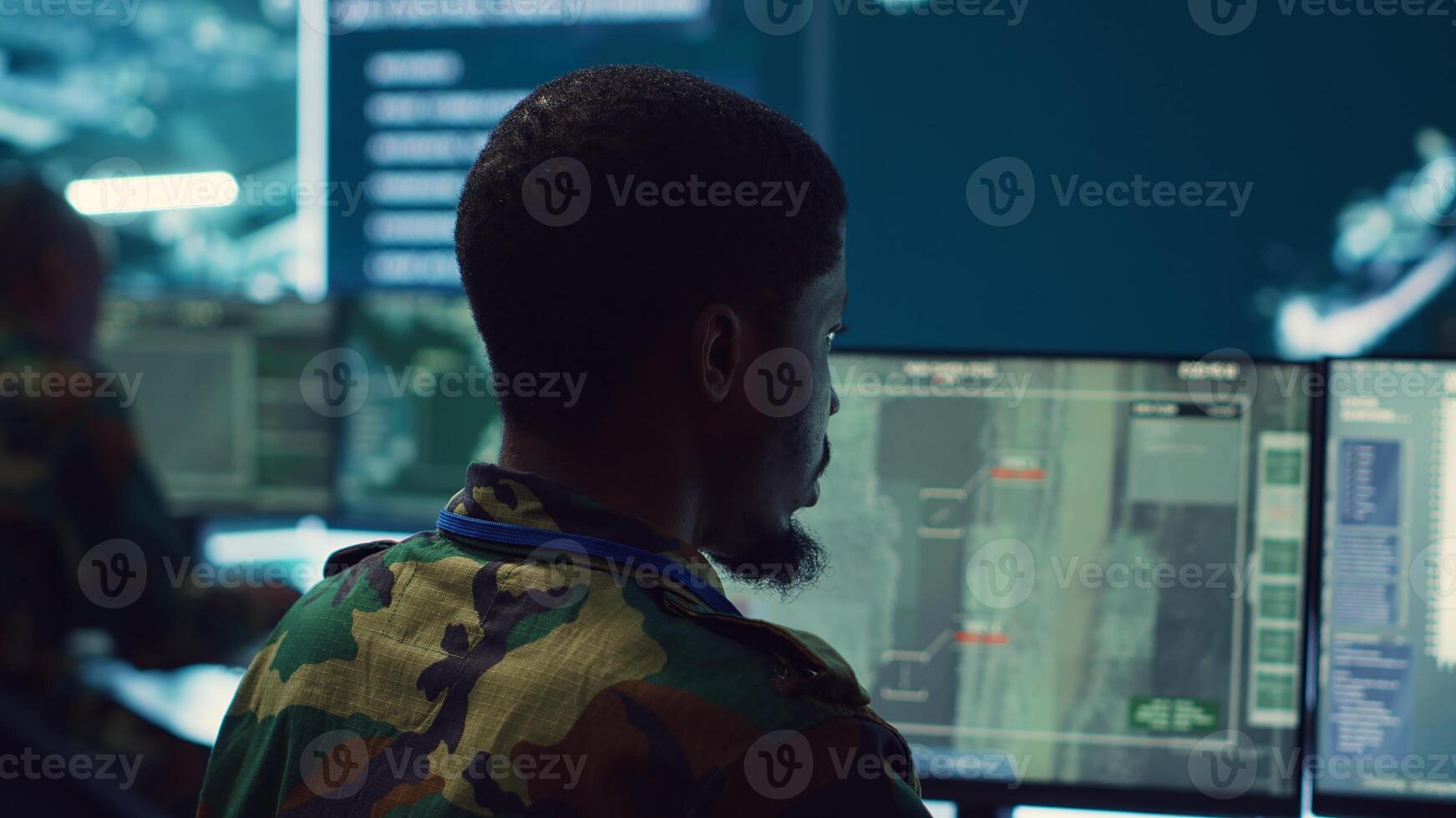 Army officer develops contingency plans to address unexpected developments in the field, studying real time satellite intelligence in military command post. Soldier tracking enemy servers. Camera A. photo