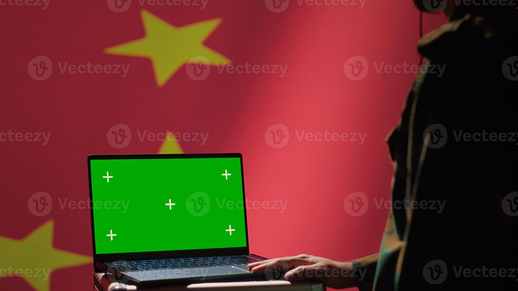 Chinese secret police agent uses mass propaganda tools on chroma key laptop to influence population minds. Communist Party regime commits PsyOp sabotage using notebook, camera A photo