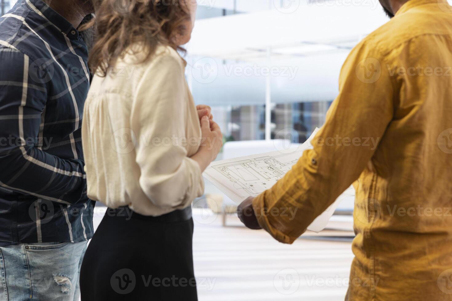 Real estate agent guiding clients on an office hunt with layout blueprints, modern architectural plans and discussing potential property investment. Relocation in a high class urban setting. photo