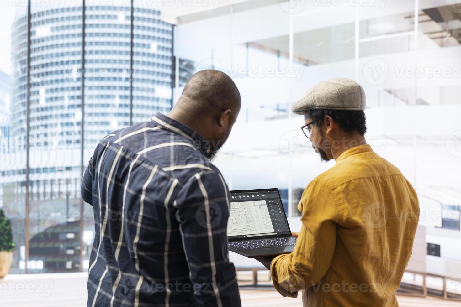 Real estate investment expert and entrepreneur planning an office space relocation, examining blueprints and discussing the layout for the new workspace. Looking to buy urban property. photo