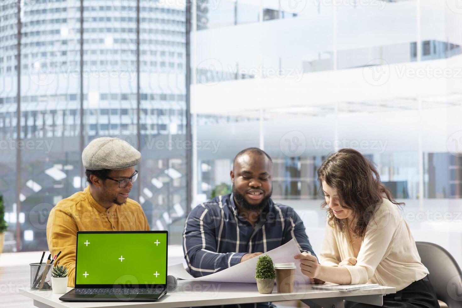 Real estate agent reviewing blueprints with entrepreneurs next to copy space, securing a contract with business partners looking to relocate their office space. High class urban building property. photo