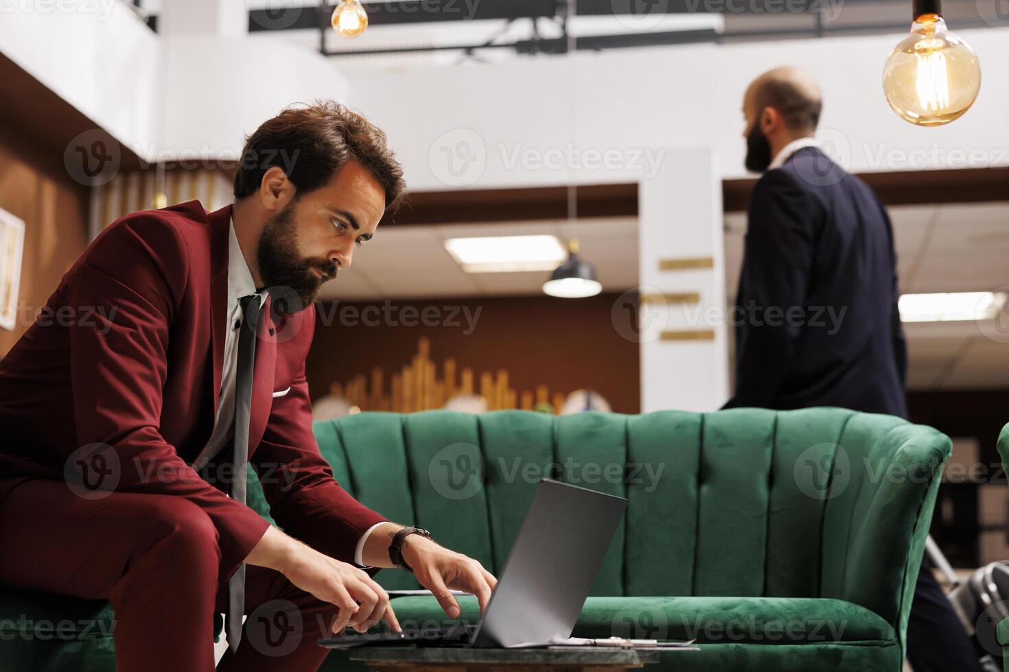 White collar worker check documents to kill time before starting meeting, sit in lounge area. Entrepreneur preparing notes for executive board presentation, luxury lobby at hotel. photo