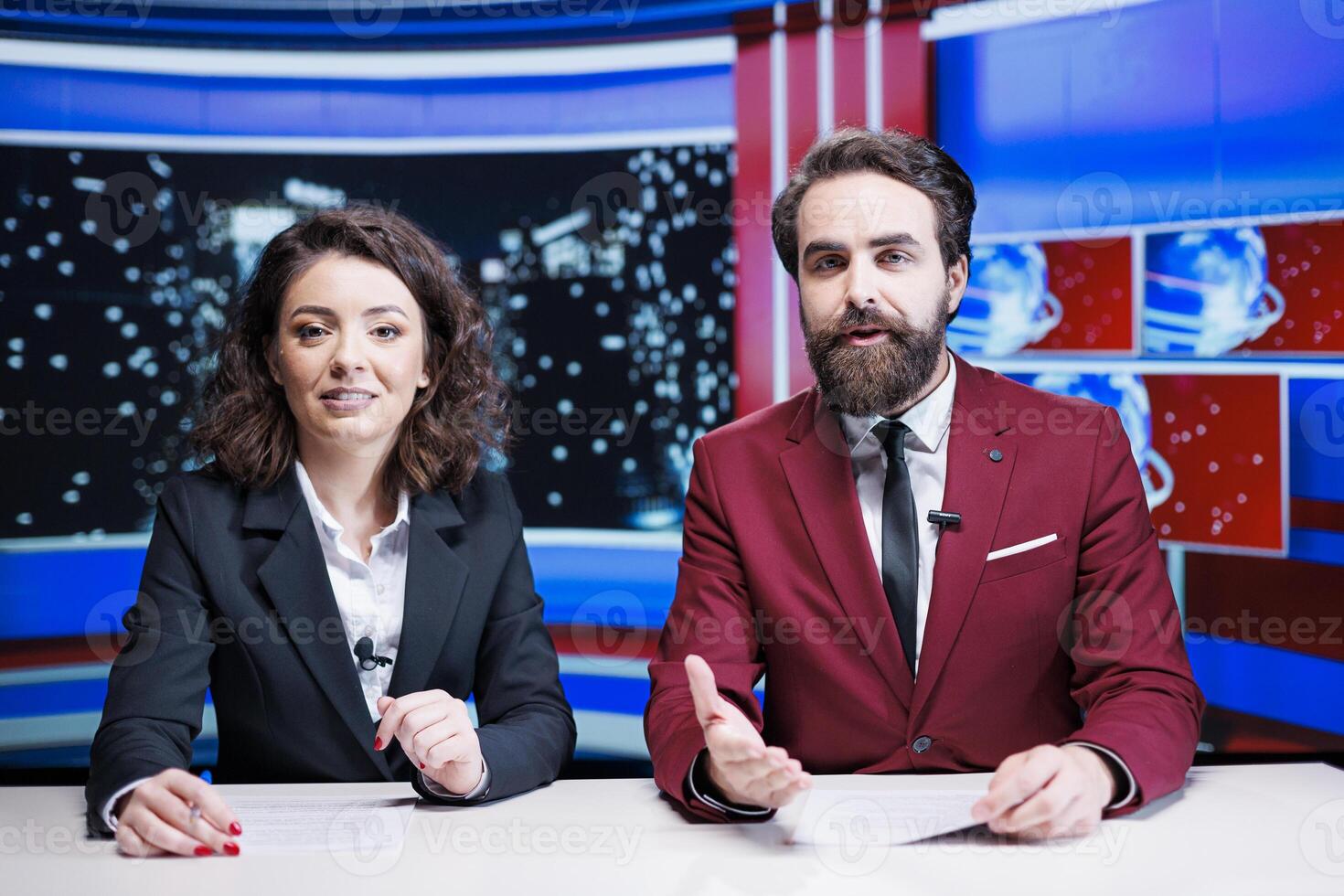 Team of reporters giving news insight presenting latest information and global events in newsroom. Two presenters working on television content, debating international problems and topics. photo