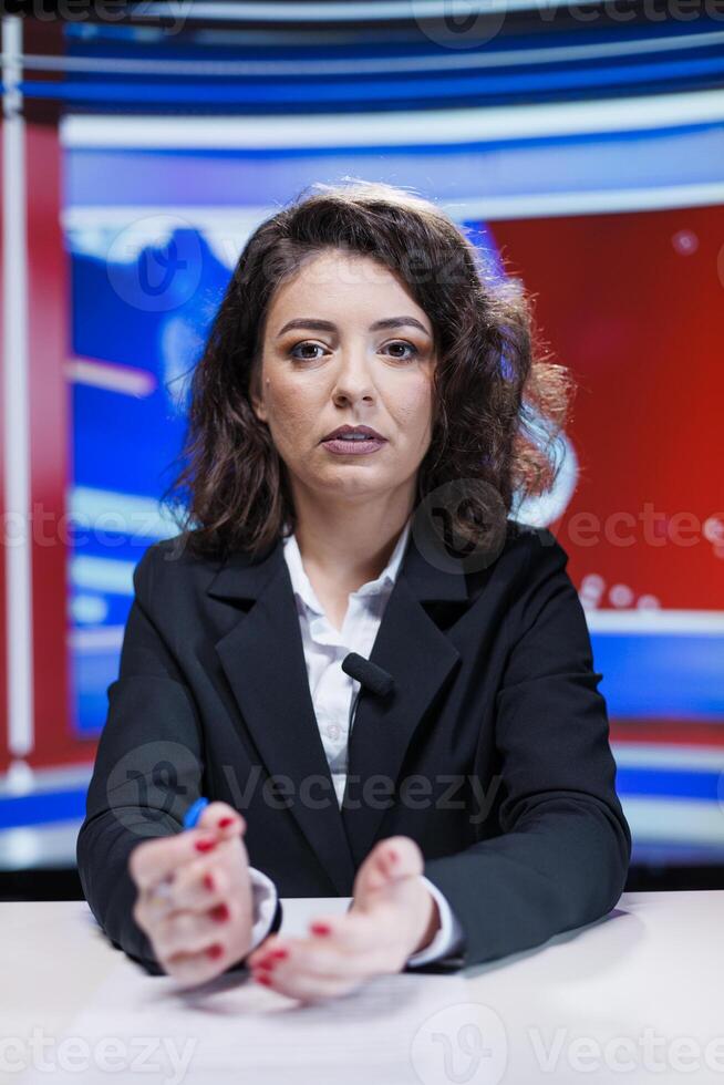 Reporter delivering major stories, broadcasting live information while reporting current events and recent developments. Researcher in newsroom speaks on TV channel about worldwide concerns. photo