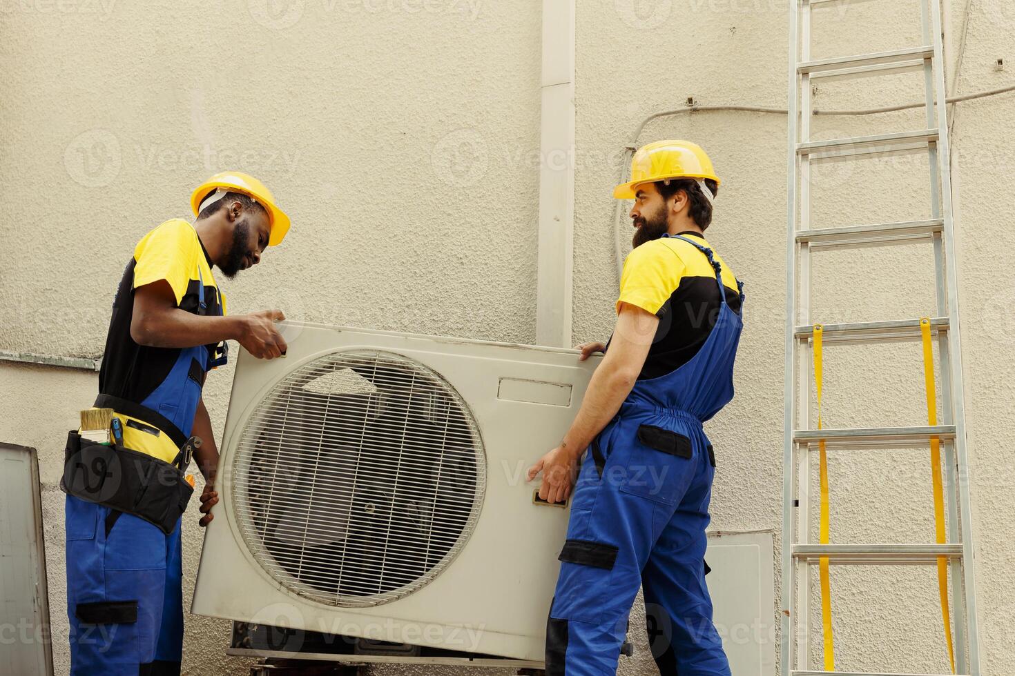 Proficient expert and knowledgeable professional pulling apart old out of order outside air conditioner to replace it with new performant condenser after draining refrigerant and replacing ductwork photo