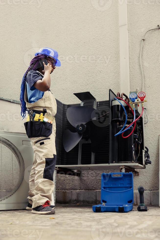 Trained engineer on the phone with home owner after finishing hvac system repairments. Certified technician calling client to inform him about built up layers of dirt found on air conditioner unit photo