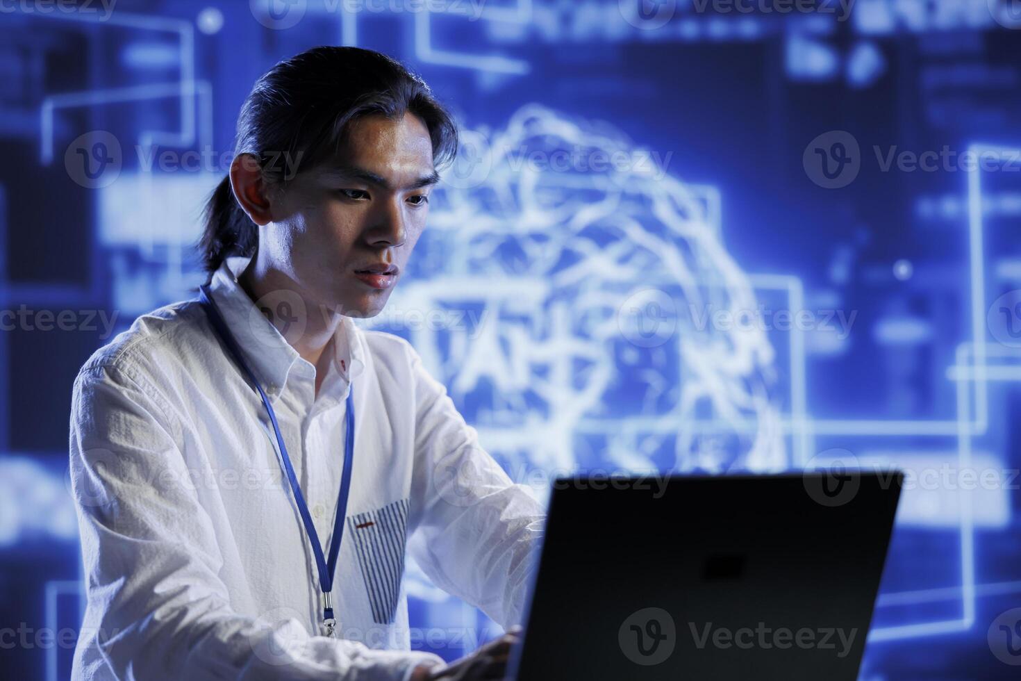 Licensed programmer in data center uses artificial intelligence computing simulating human brain through self learning algorithms. Adept professional holds laptop, working with AI deep neural networks photo