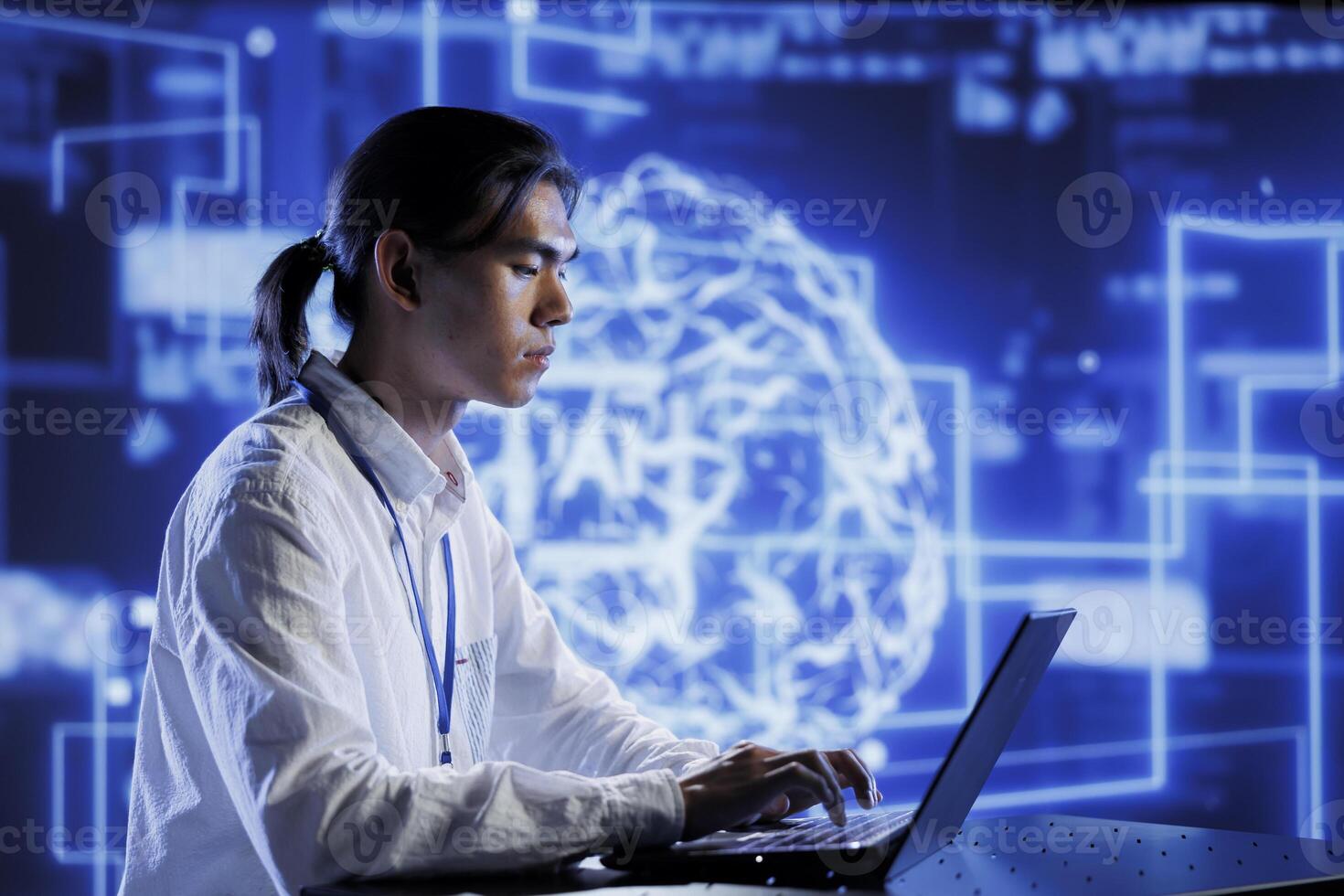 Trained technician in data center uses artificial intelligence computing simulating human brain through self learning algorithms. Knowledgeable expert with laptop working with AI deep neural networks photo