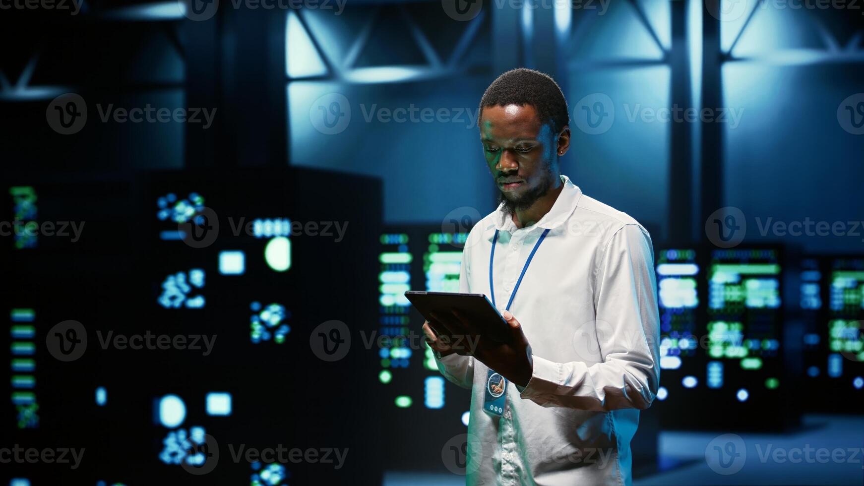 IT programmer in server hub using tablet to find firewall misconfigurations affecting mainframes performance and connectivity, leading to slow data transfer rates and poor client communication photo