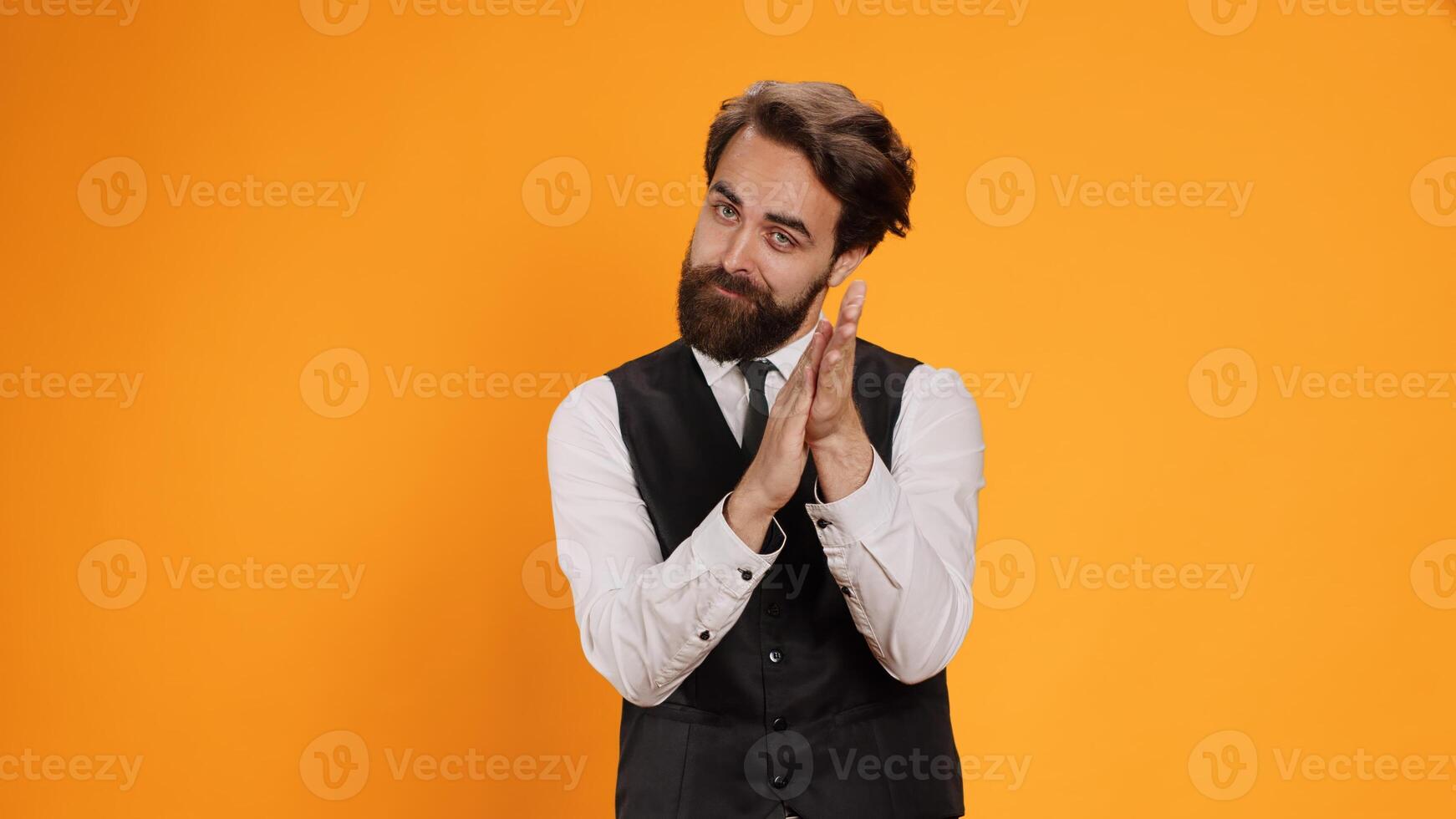 Friendly waiter clapping hands in admiration as they applaud somebody on camera for their achievements. Enthusiastic server in formal outfit offers someone encouraging morale lift. photo