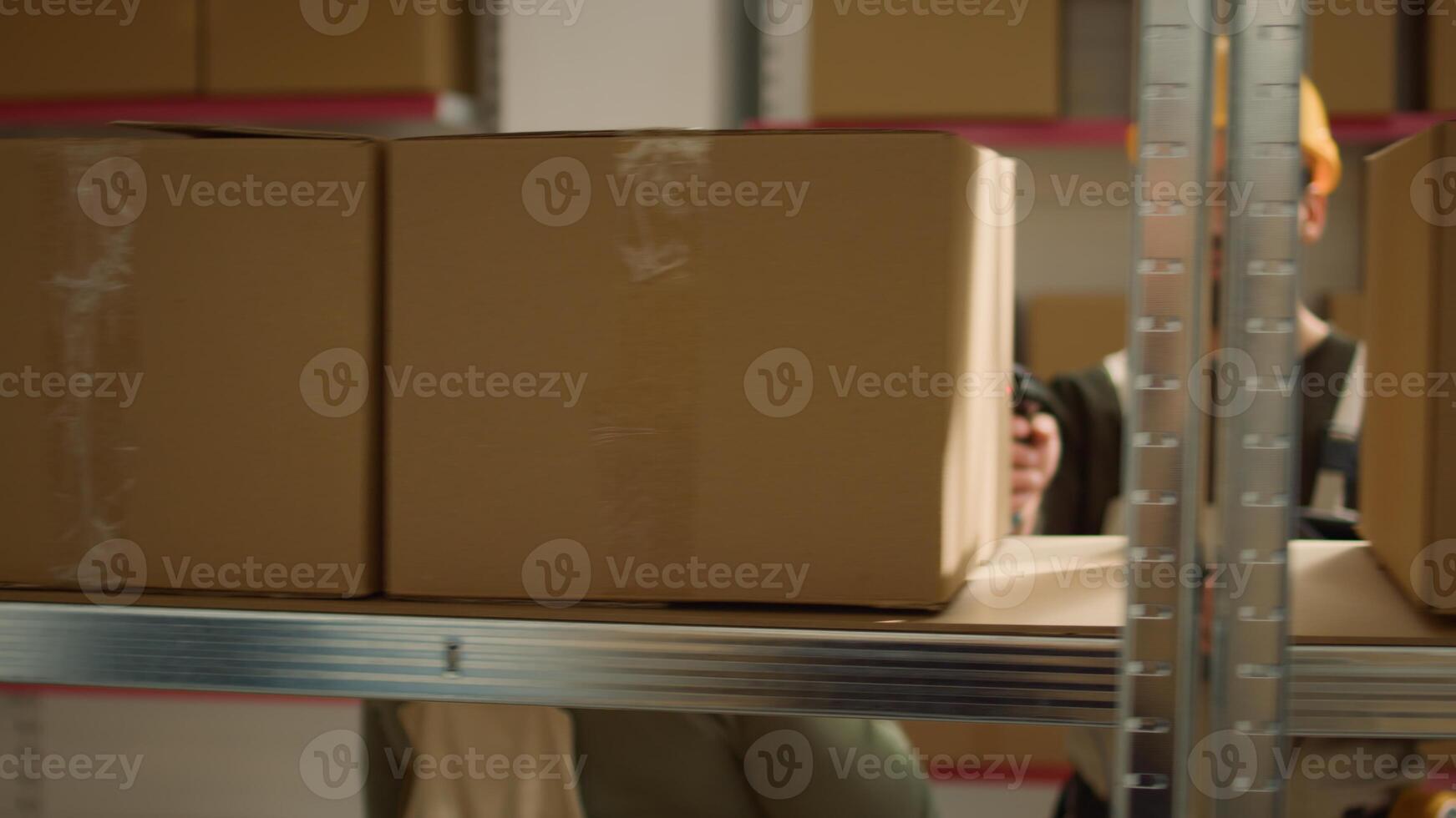Focused warehouse employee and colleague scanning cardboard boxes on cabinet shelves, updating storage room merchandise labels info before sending parcels to be dispatched photo