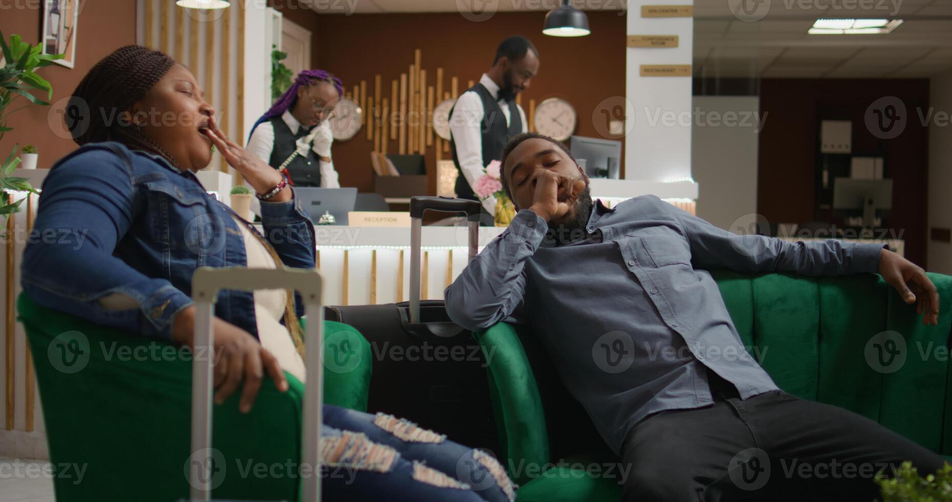 Exhausted people resting in hotel lobby, waiting for registration and falling asleep after long day of flying. African american couple being sleepy and napping in lounge area at resort, jetlag. photo