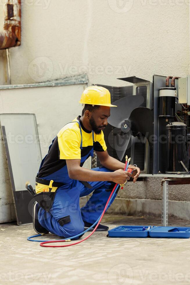 Knowleadgeable engineer doing annual hvac system maintenance, assembling manometers before starting work. Certified technician getting pressure checking tool ready for air conditioner freon tank photo
