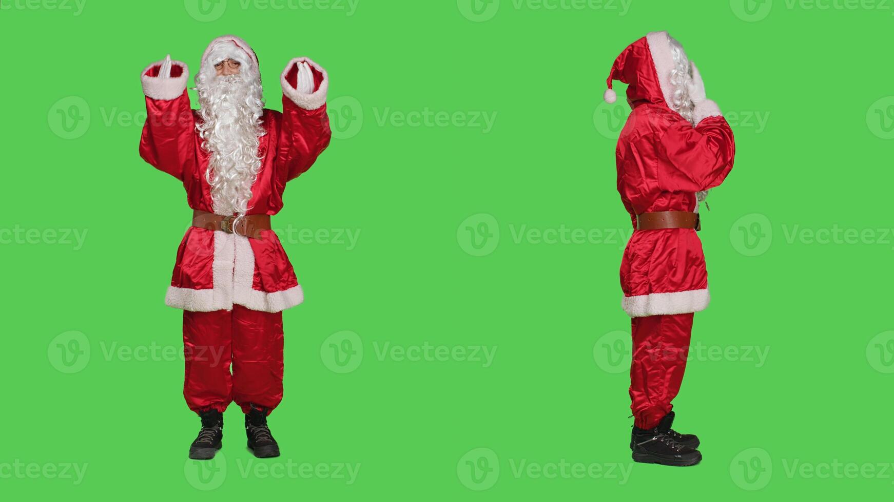 Saint nick arguing with someone, having heated argument over full body greenscreen backdrop. Young man portraying santa claus in festive costume, conflict and disapprovement concept. photo