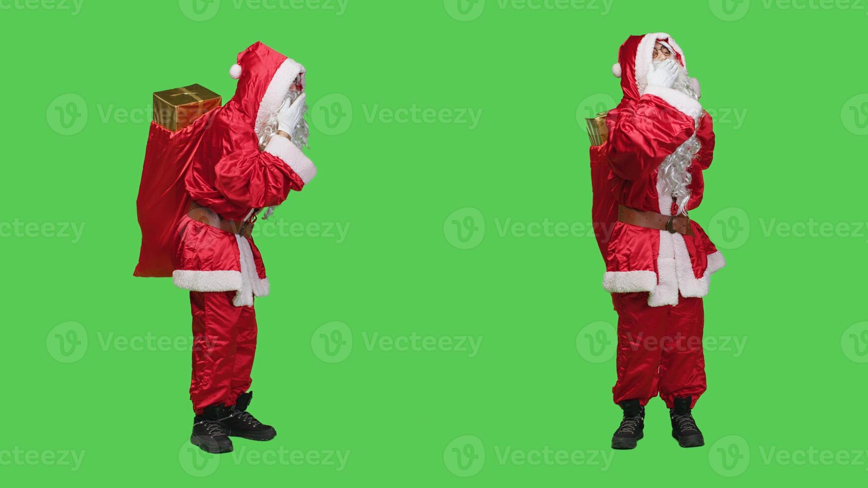 Flirty santa claus gives air kisses to spread positivity and chrsitmas spirit, acting romantic and sweet over full body greenscreen. Young man dressed as saint nick in costume with hat, cute gesture. photo