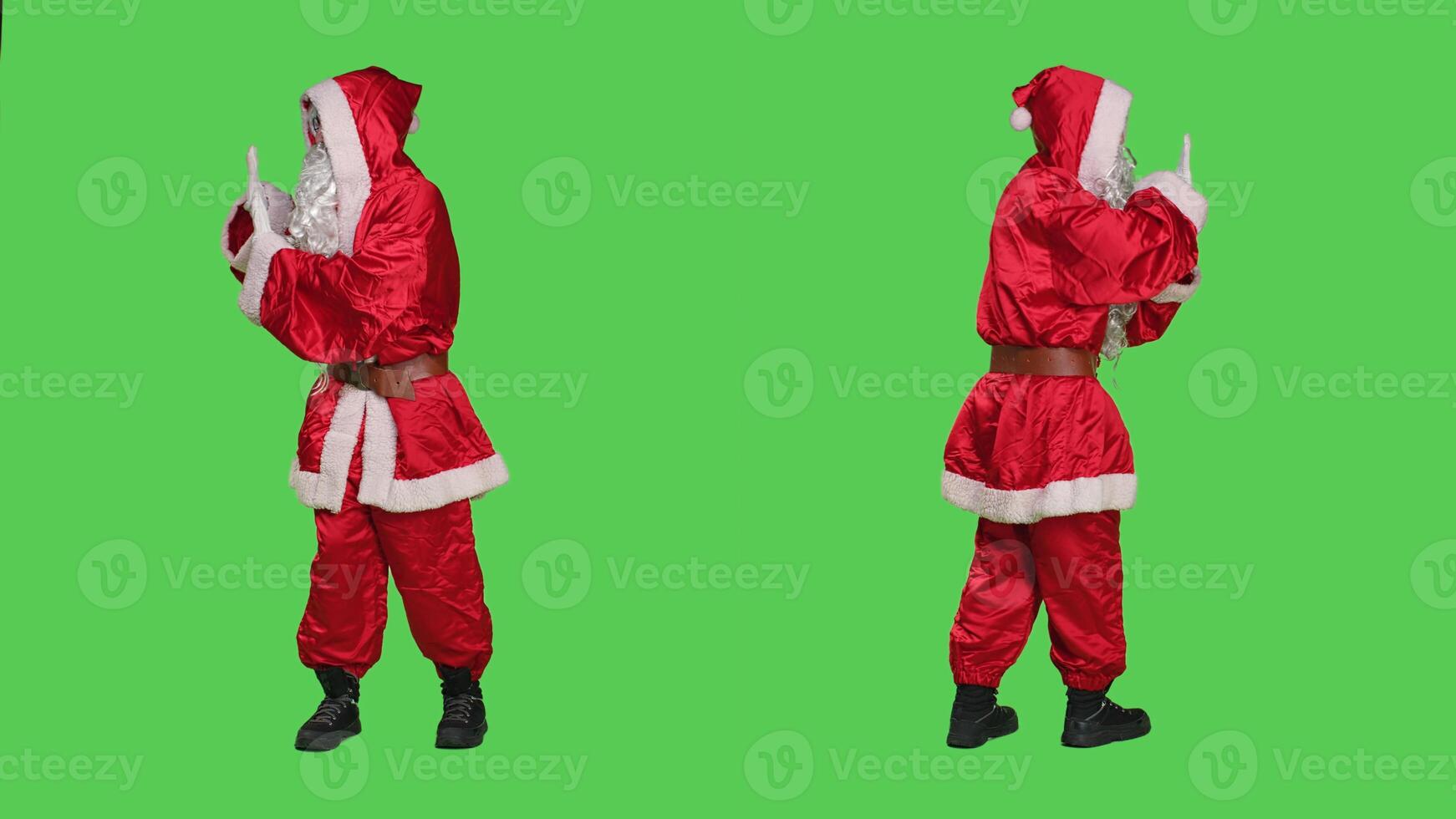 Father christmas pretends to push something aside, wearing winter character costume with hat. Santa claus pushing object as rejection, dismissing thing sideways over greenscreen. photo