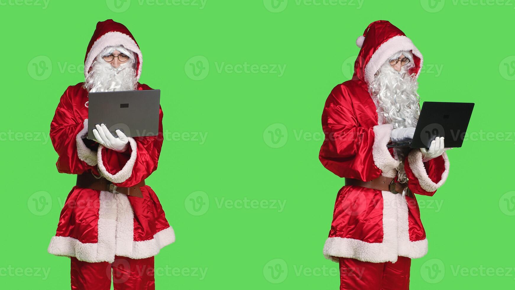 Man in santa costume using laptop to see naughty or nice children list, looking around the globe to send presents on christmas eve. Father christmas concept, person on greenscreen. photo