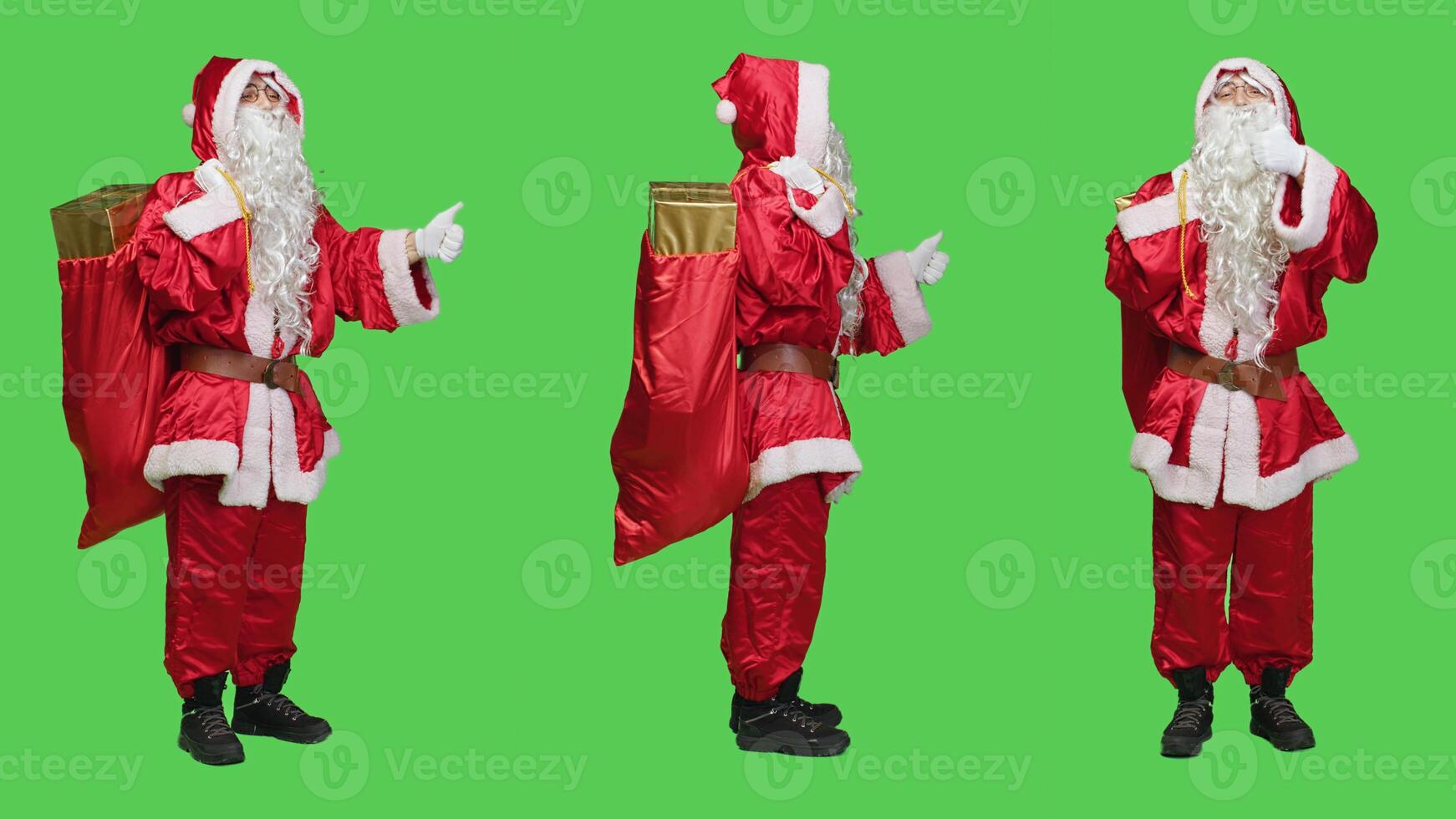 Father christmas gives thumbs up in studio, feeling cheerful showing approval and agreement sign over full body greenscreen. Saint nick in red suit does okay symbol, positivity. photo